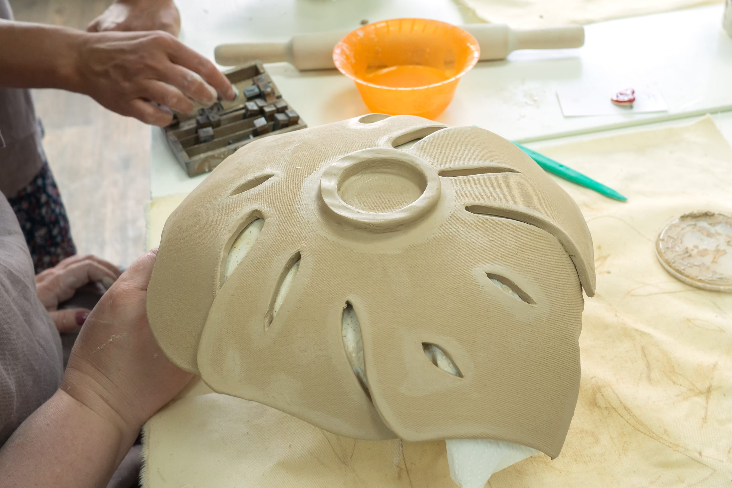 Woman,Hand,Potter,Making,Clay,Monstera,Leaf,In,Pottery,Workshop